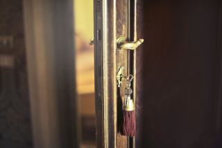 Clé engagée dans la serrure d’une porte d’entrée en bois entrouverte